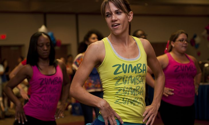 Jennifer Stewart, Zumba instructor, demonstrates a workout routine during a Military Spouse Appreciation Day event May 11, 2012, at Nellis Air Force Base, Nev. Zumba aerobics is one class that military spouses can attend at the Warrior Fitness Center to increase their physical fitness. (U.S. Air Force photo by Airman 1st Class Jason Couillard)